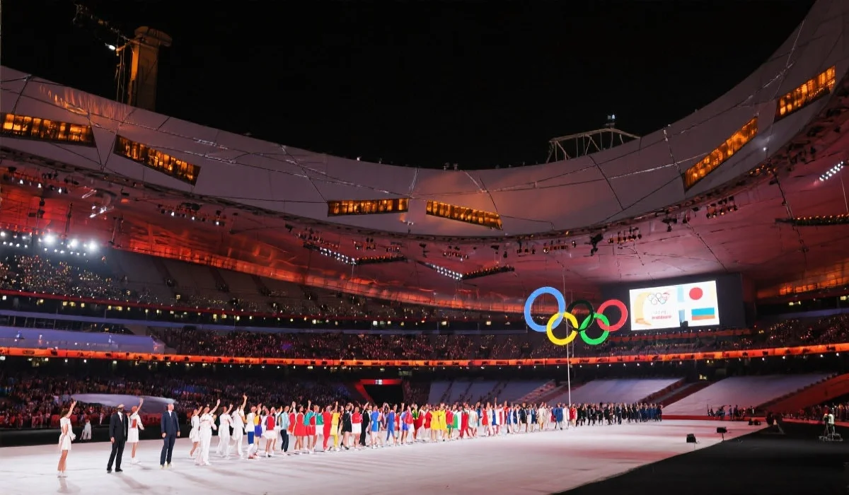 现代奥运会主体育场夜景,五环标志与各国运动员列队入场,灯光璀璨